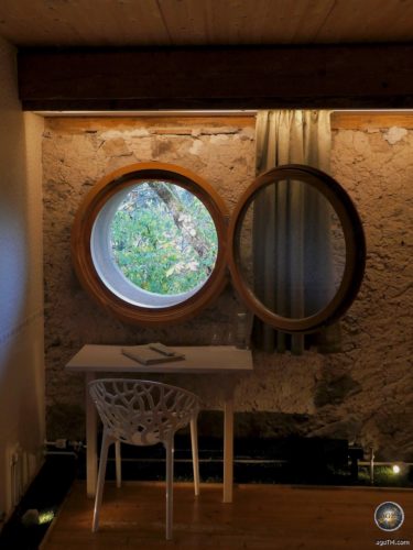 Foto zeigt ein Bullauge in einer natürlichen Steinwand im Blumen-Zimmer. Fotografiert im Schwarzwald-Hotel Rainhof Scheune.