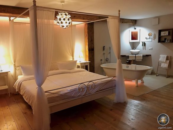 Foto zeigt ein Himmelbett und eine freistehende Badewanne im Romantik-Zimmer. Fotografiert im Schwarzwald Hotel Rainhof Scheune.