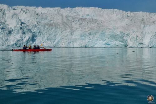 Ein Kajak paddelt vor der imposanten Gletscherabbruchkante des Monaco-Gletschers in Spitzbergen